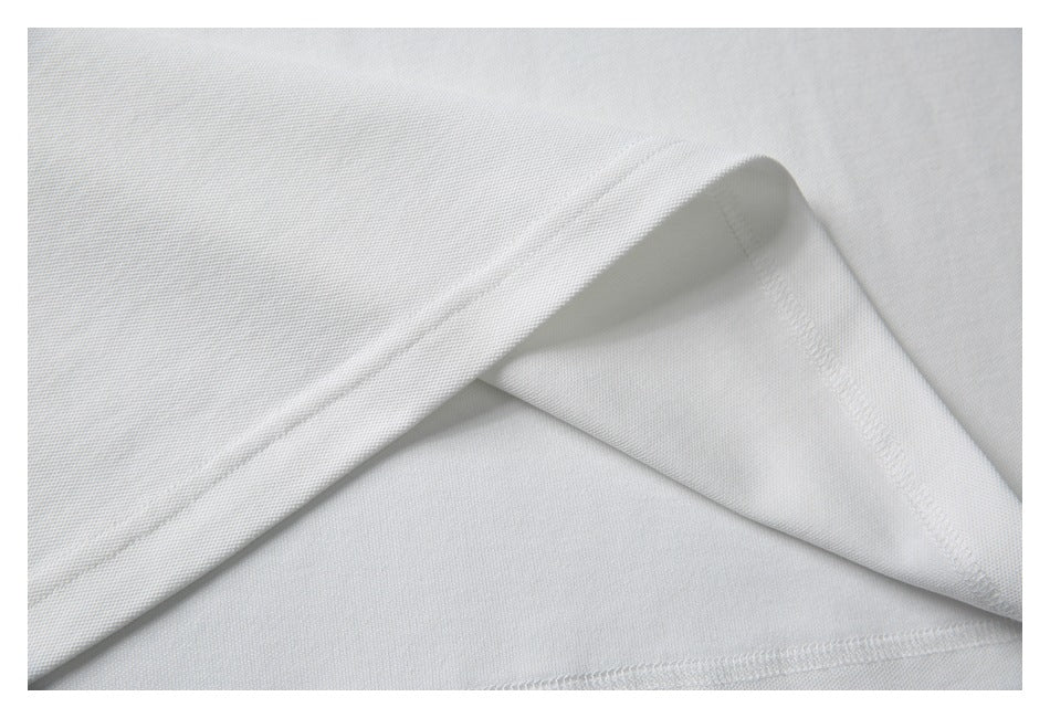 Close-up of white garment fabric folded to show stitched seams and the inside finish.