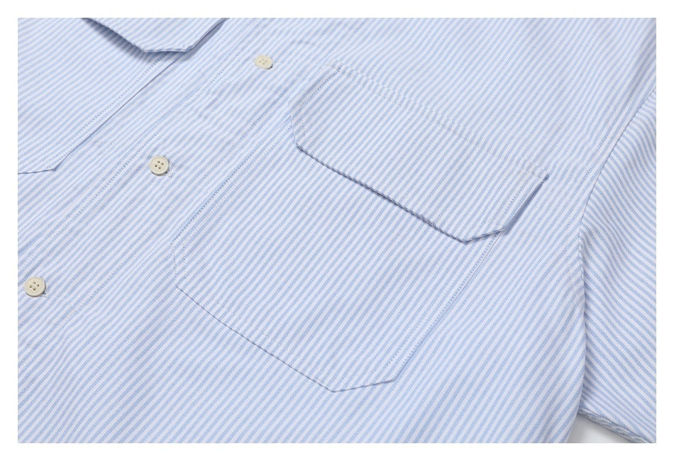Close-up of a blue-and-white striped shirt front with a button placket and chest pocket.