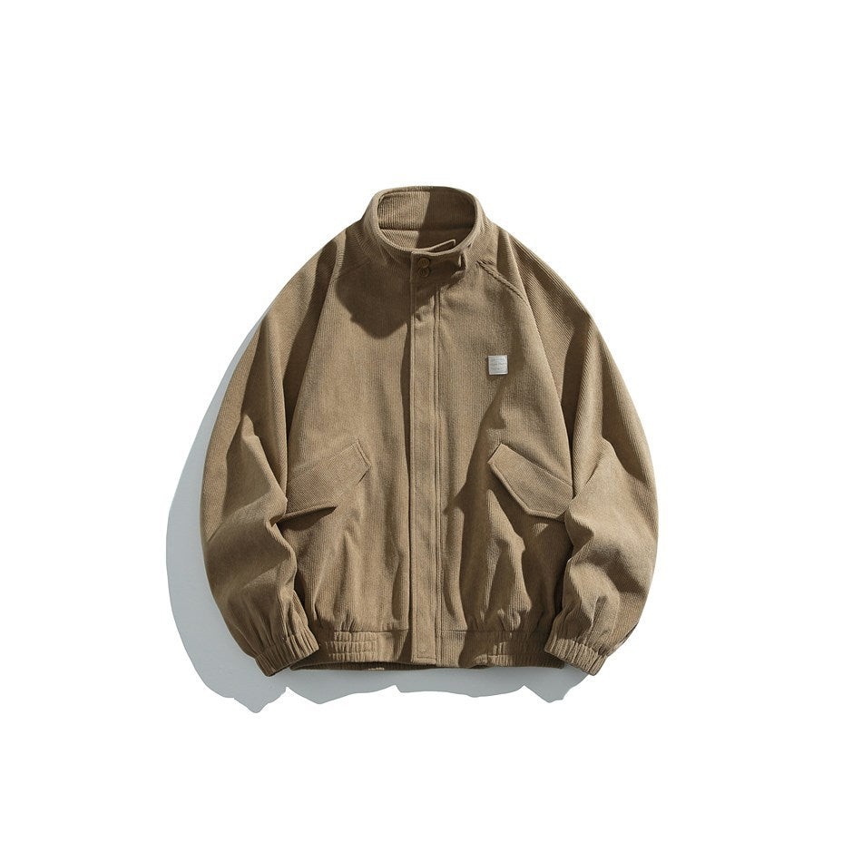 Light brown ribbed stand-collar jacket with front placket, flap pockets, chest patch and elastic cuffs, flat lay