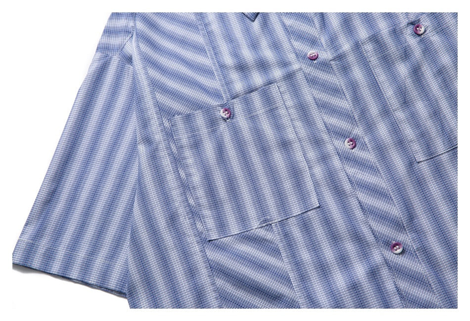 Close view of the blue-and-white checked shirt front with a chest pocket, buttons, and sleeve.