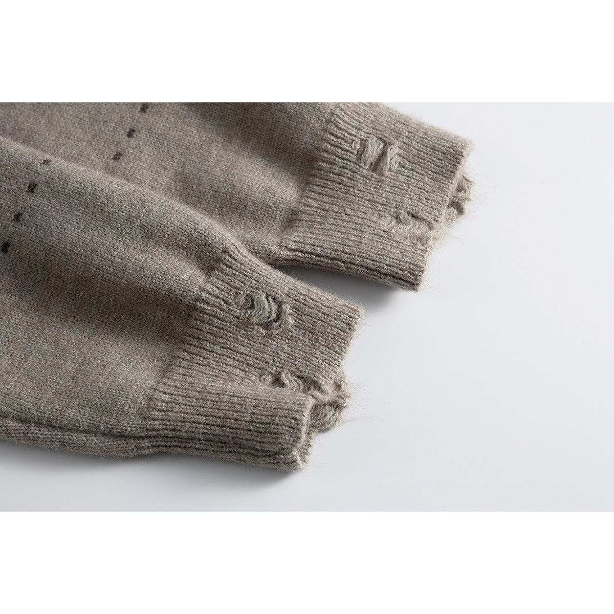 Close-up of the taupe cardigan's long sleeve cuffs, showing ribbing and distressed knit details.
