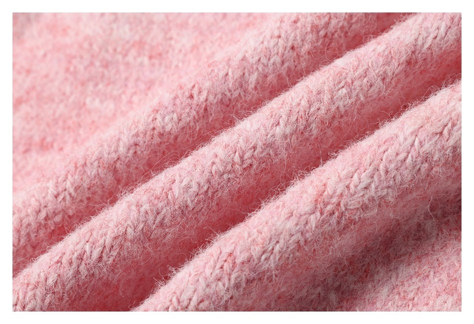 Macro view of fuzzy pink knit stitches and raised fabric folds.