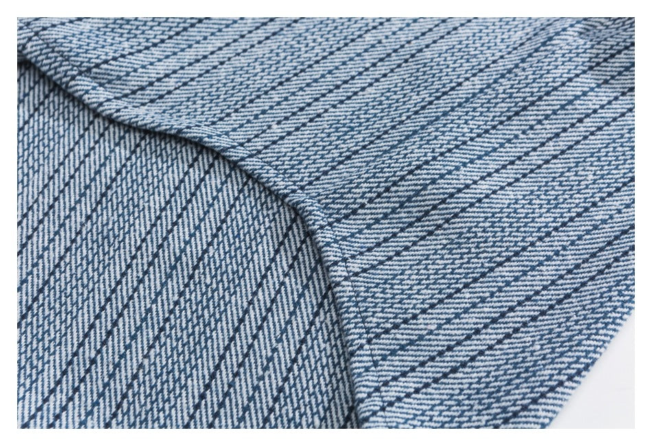 Close-up of a blue-and-white patterned garment seam and overlapping fabric panels.