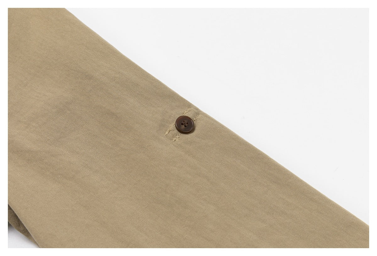 Close-up of a dark button and buttonhole on the khaki garment.