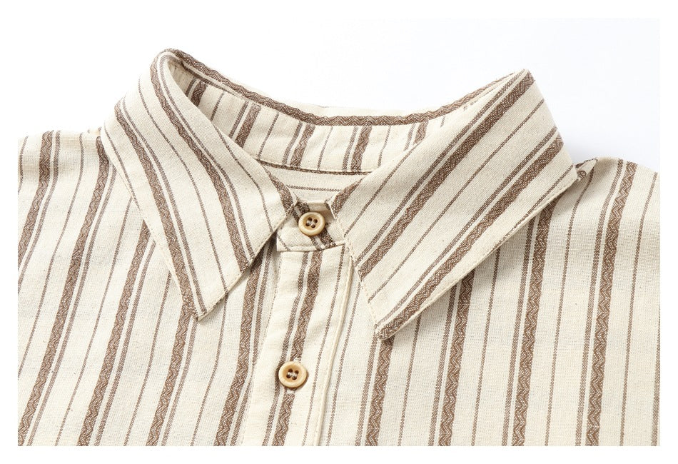Close-up of a cream shirt collar and front buttons with brown vertical stripes.