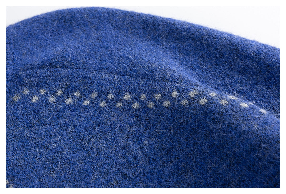 Close-up of the blue knit sweater's fuzzy texture and a row of small light-colored motifs.