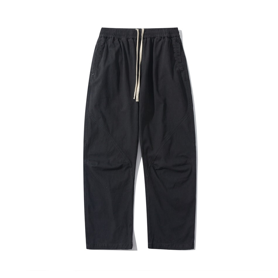 Black straight-leg drawstring pants with elastic waistband and diagonal seams, flat front view