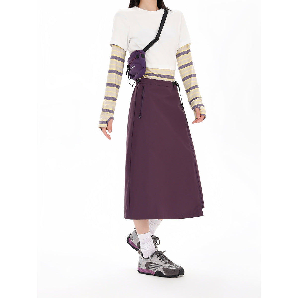 Model wearing a plum A-line midi skirt with a side zipper and black buckle belt.