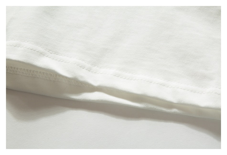 Close-up of the double-stitched and overlocked hem of a white garment.
