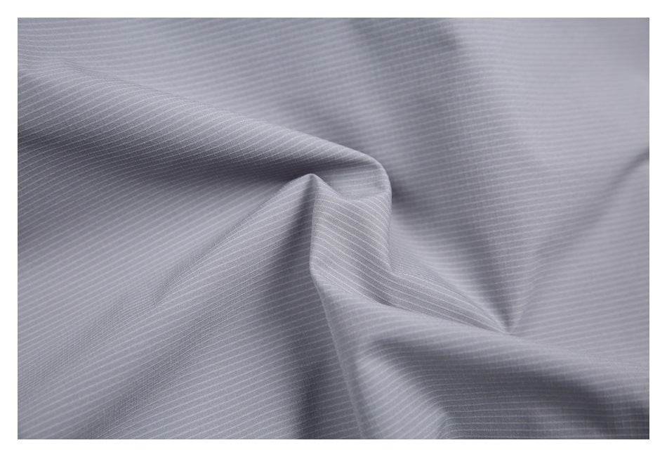 Close-up of gray fabric with fine, evenly spaced stripes, shown draped in folds.