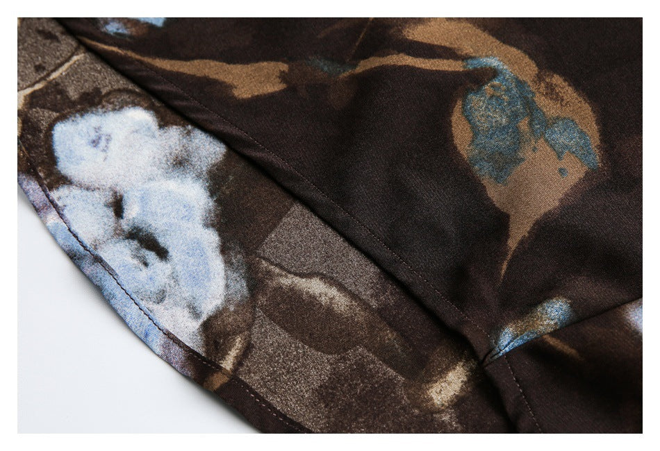 Close-up of the dark brown shirt's abstract blue and tan print and stitched seam.