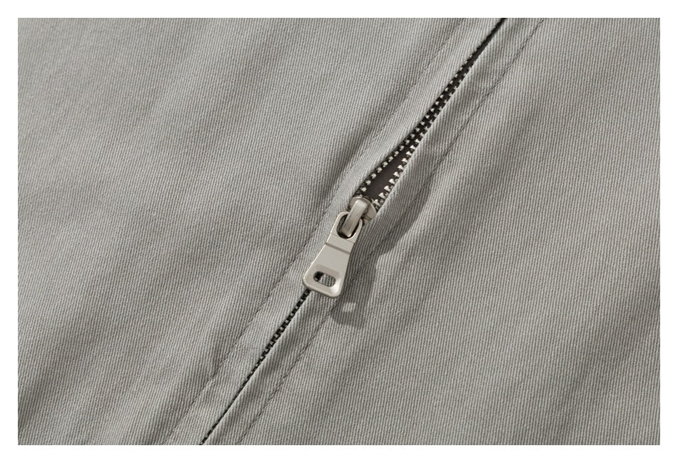 Close-up of the gray jacket's metal front zipper and pull.