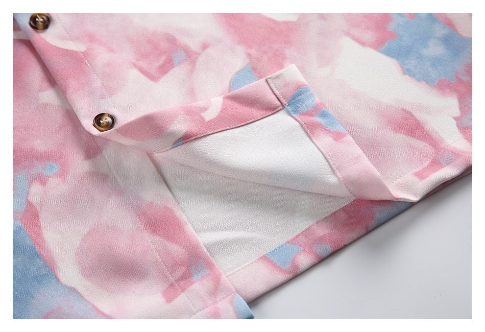Close-up of pink and blue abstract-print garment showing brown buttons, a seam, and a white-lined pocket.