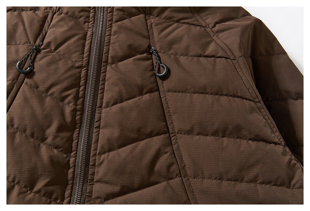 Close-up of a brown quilted jacket showing its front zipper and two zippered pockets with loop pulls.