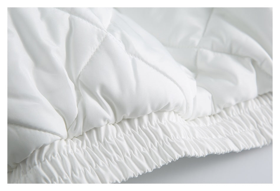 Close-up of a white padded garment showing stitched sections and a gathered elastic edge.