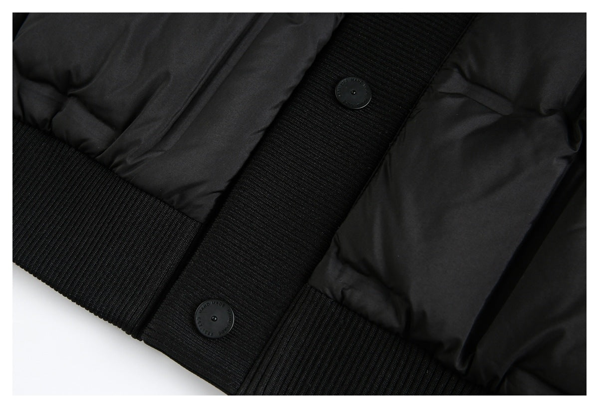 Close-up of the black jacket's ribbed hem, buttoned placket, and quilted body.