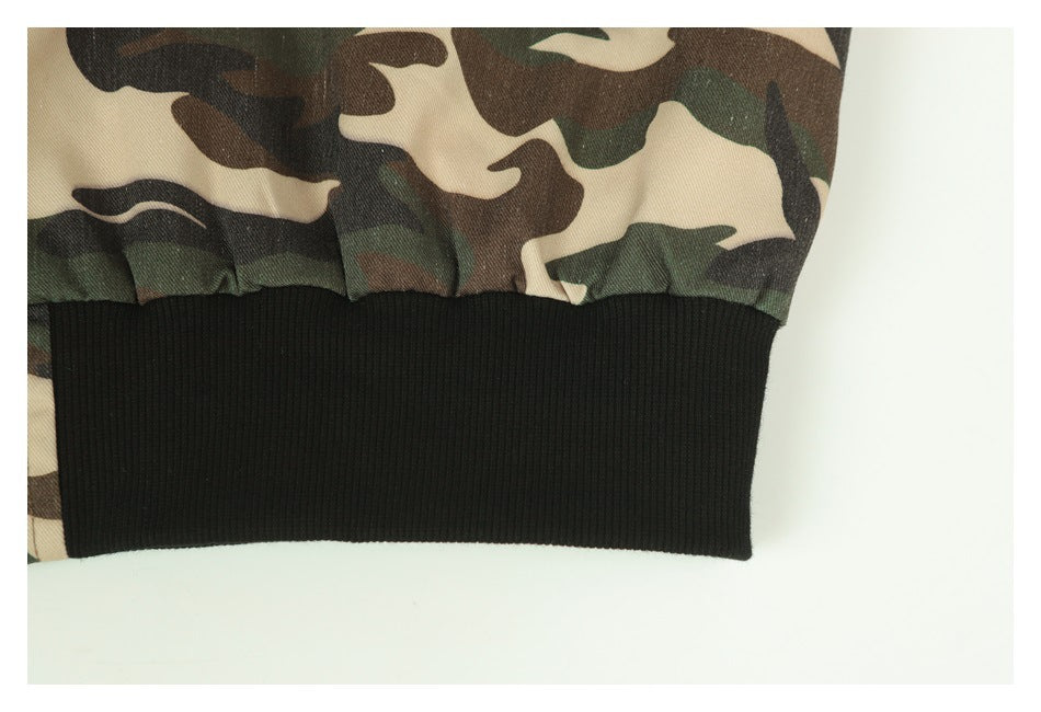 Close-up of a wide black ribbed cuff attached to the camouflage jacket sleeve.