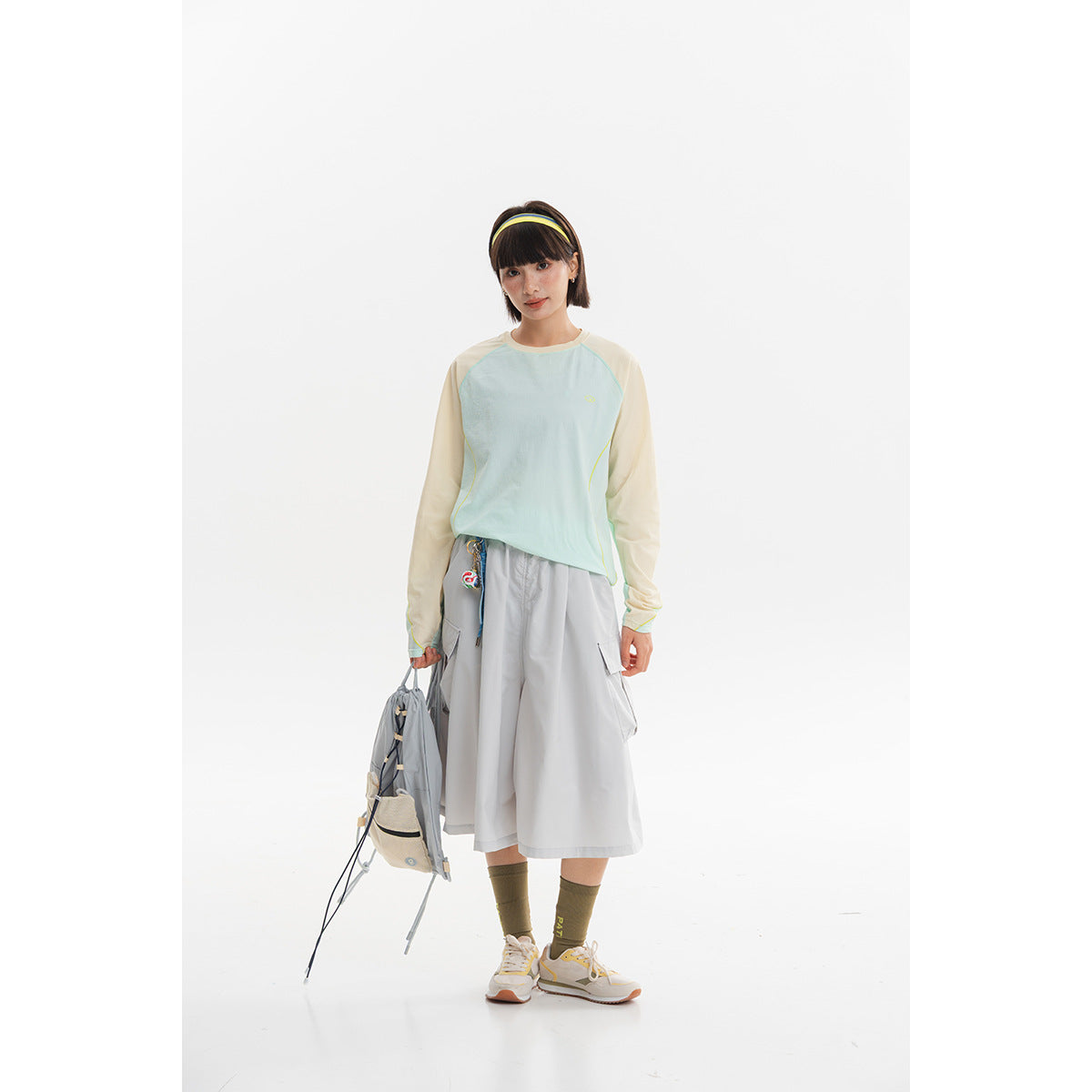 Model wearing a pale aqua long-sleeve top and gray wide midi cargo skirt with sneakers.