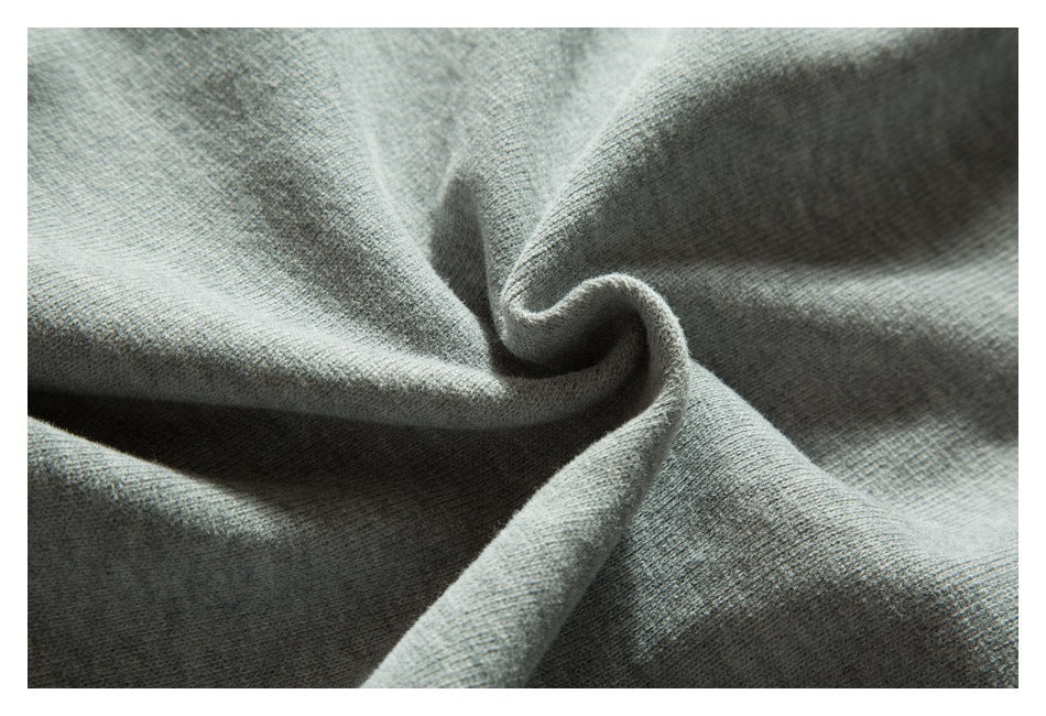 Close-up of gray knit fabric gathered into soft folds, showing its fine textured surface.