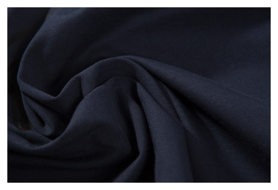 Close-up of navy T-shirt fabric gathered into soft folds.