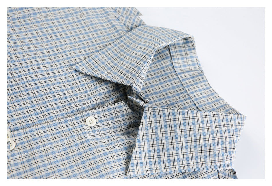 Close-up of a blue plaid shirt collar, button placket, and white buttons.