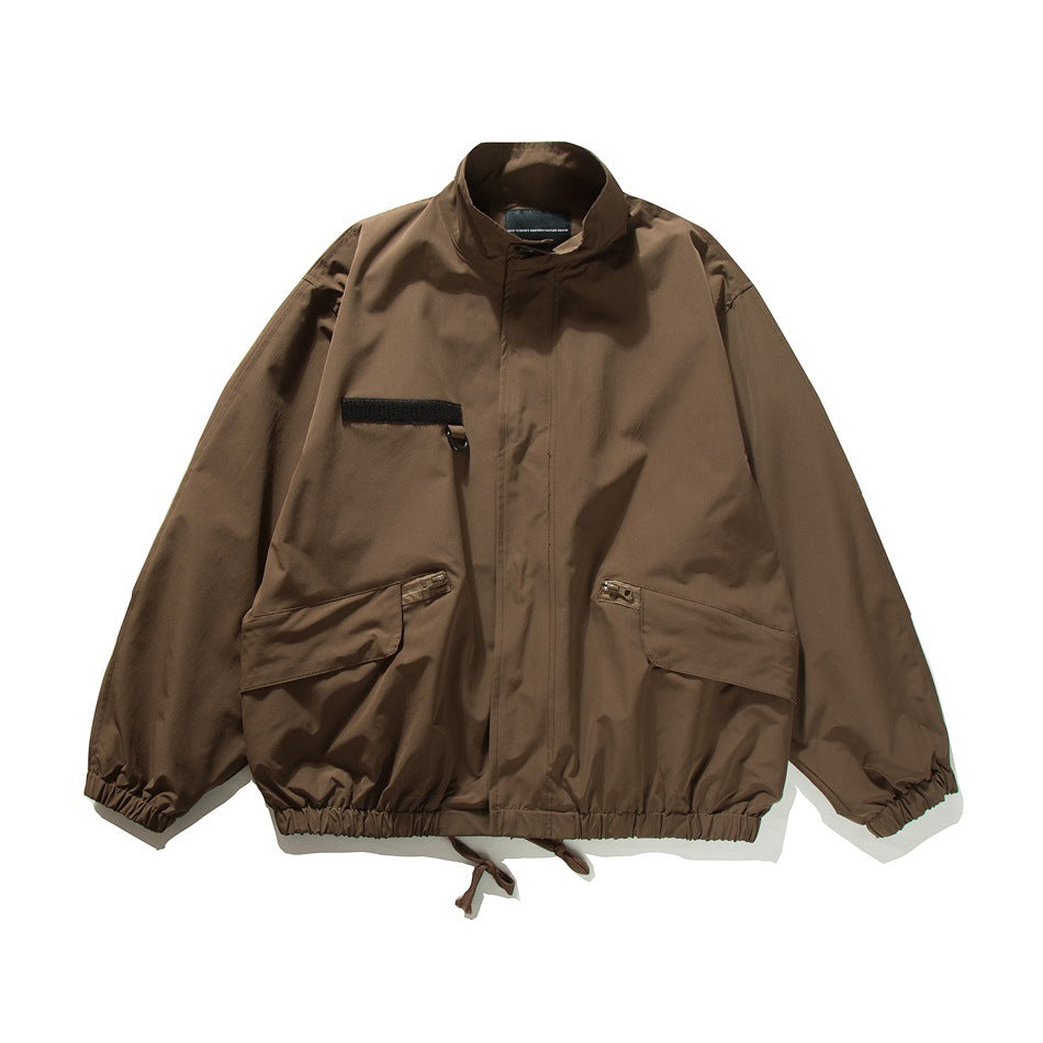 Brown stand-collar bomber-style jacket, flat front view with chest patch, flap pockets and drawcord hem