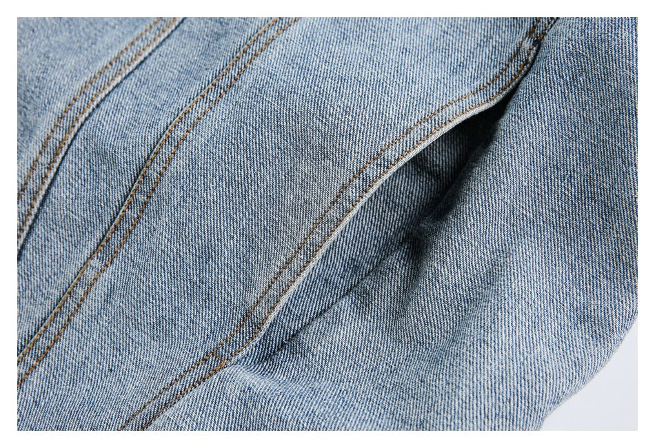 Close-up of folded light blue denim showing layered seams and contrasting stitching.
