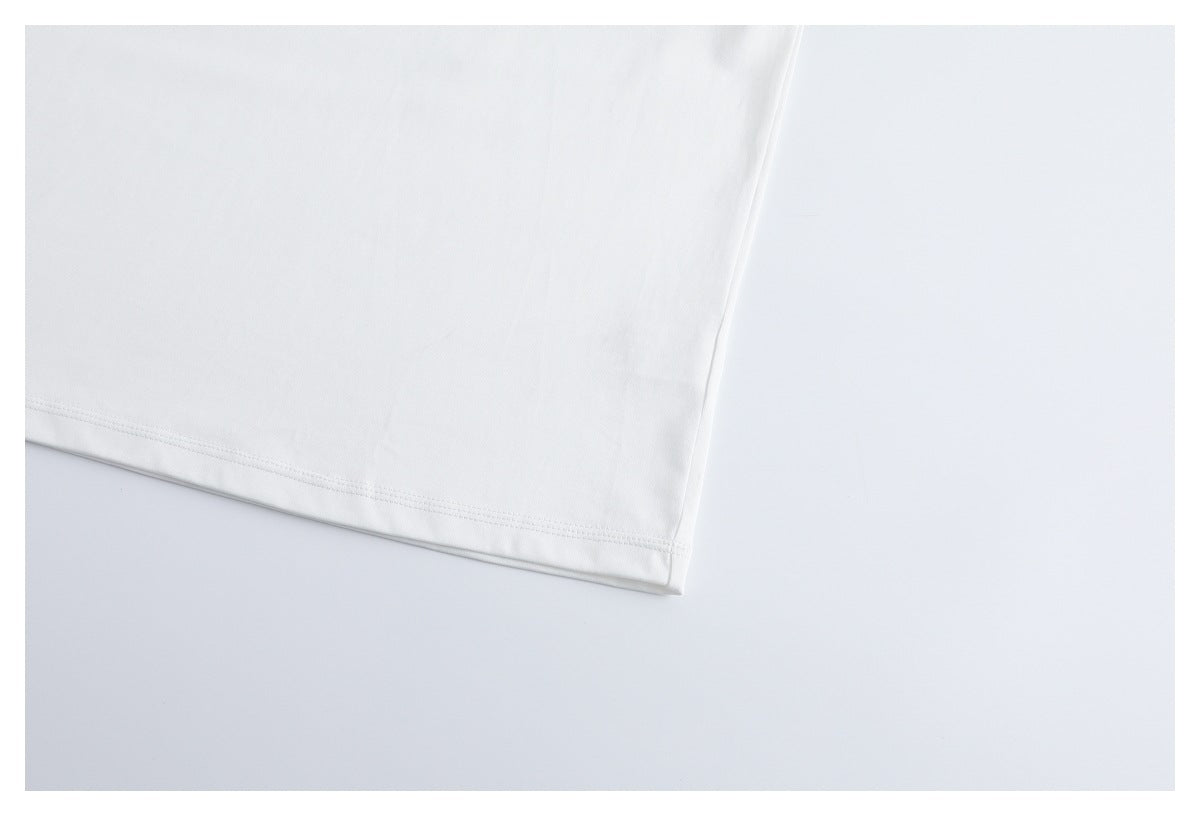 Close-up of the white T-shirt's straight stitched bottom hem.