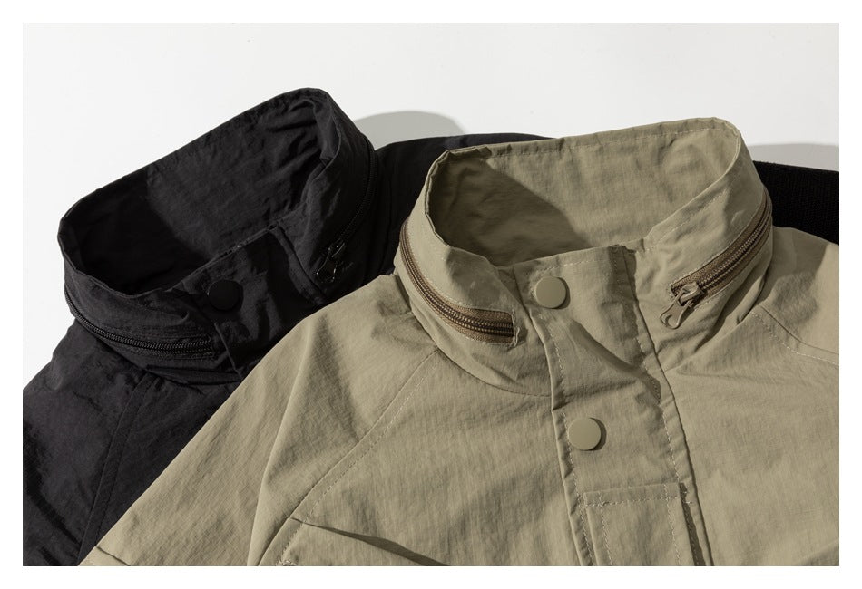 Close-up of khaki and black jackets showing their high collars, zippers, and snap-button plackets.