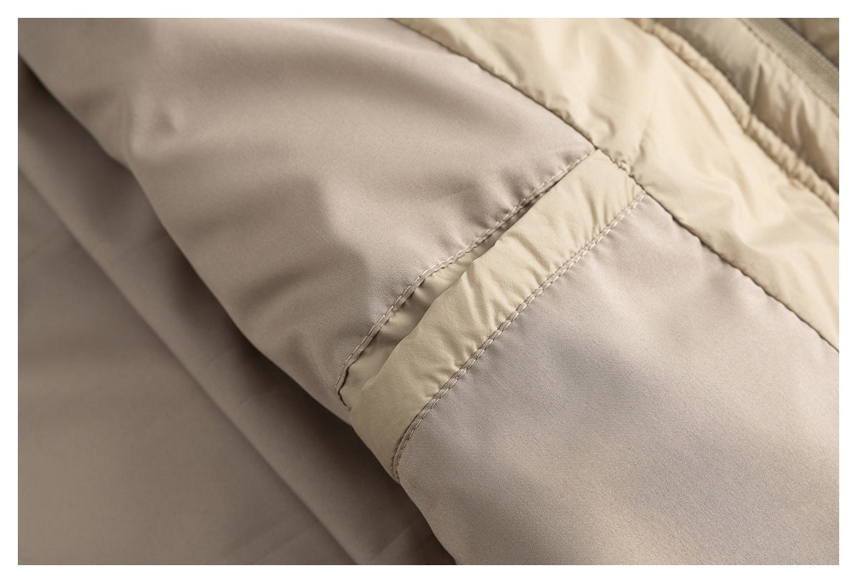 Close-up of beige jacket fabric and stitched panel seams.