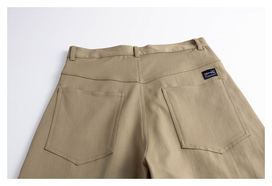 Rear view of tan trousers with belt loops, a back yoke, and two large patch pockets.