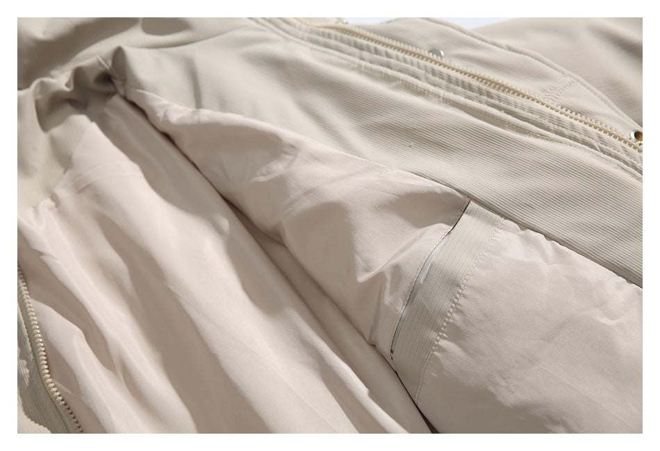 Close-up of the beige jacket opened to show its smooth pale lining and inner seams.
