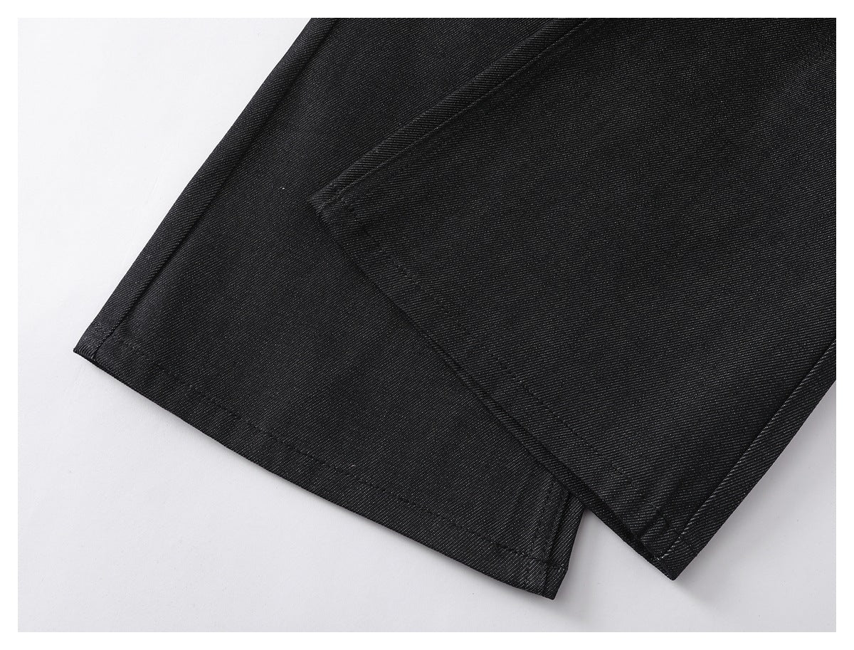 Close-up of the black pants' leg hems and stitched seams.