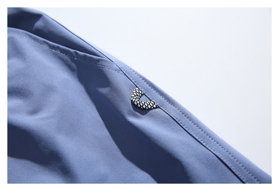 Close-up of a black-and-white braided loop attached near the stitched edge of blue shorts.