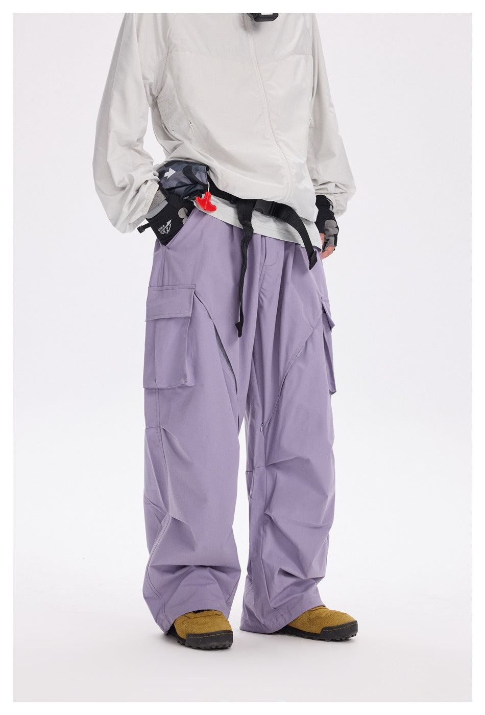 Front view of a model wearing loose lavender cargo pants with large flap pockets and angular panel seams.
