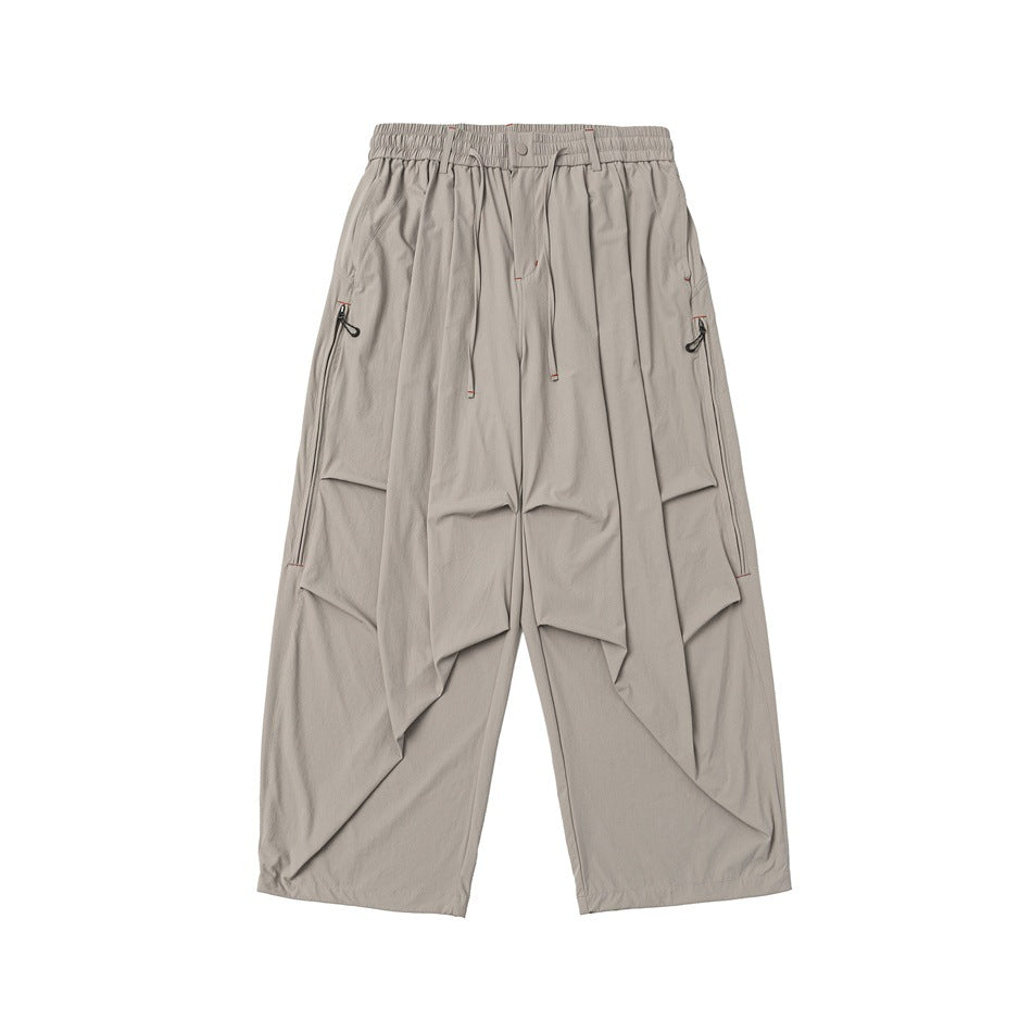 Beige khaki wide-leg pants, front flat lay with drawstring waist, pleated thighs and zippered side pockets