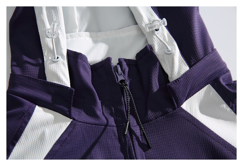 Close-up of the purple jacket front zipper, white trim, and drawcord toggles.