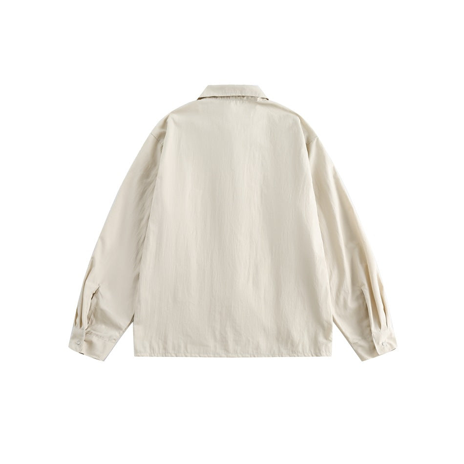 Back view of a light cream long-sleeve collared shirt laid flat, with buttoned cuffs.
