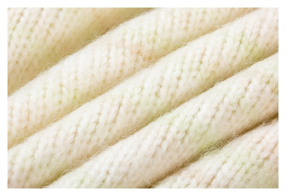 Extreme close-up of thick, fuzzy ivory knit yarn in diagonal rows.
