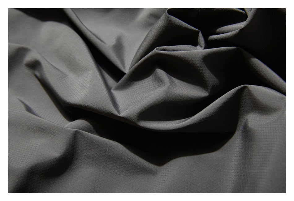 Close-up of dark gray garment fabric showing a subtle small-scale textured pattern.