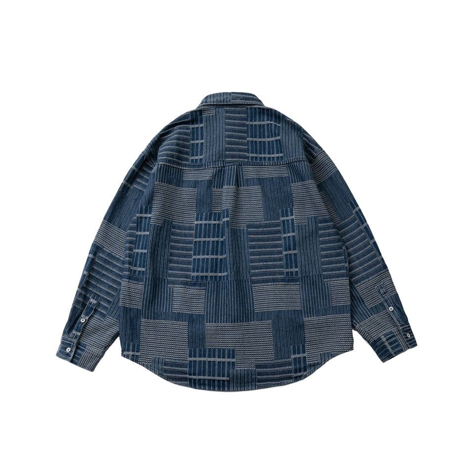 Back view of blue patchwork-pattern long-sleeve shirt with back yoke, laid flat, with buttoned cuffs