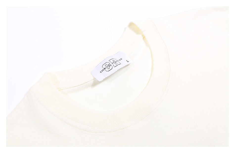 Close-up of the ivory T-shirt's ribbed crew neck and attached size L label.