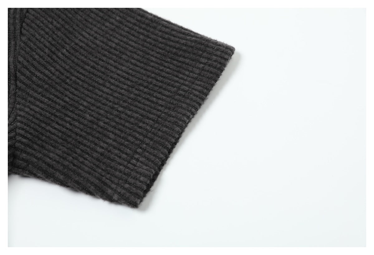 Close-up of the dark charcoal shirt's ribbed sleeve cuff.