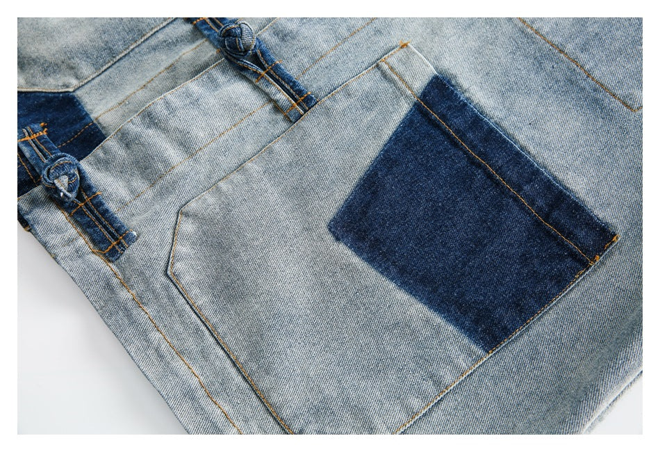 Close-up of a dark indigo contrast patch pocket on the faded blue denim jacket.