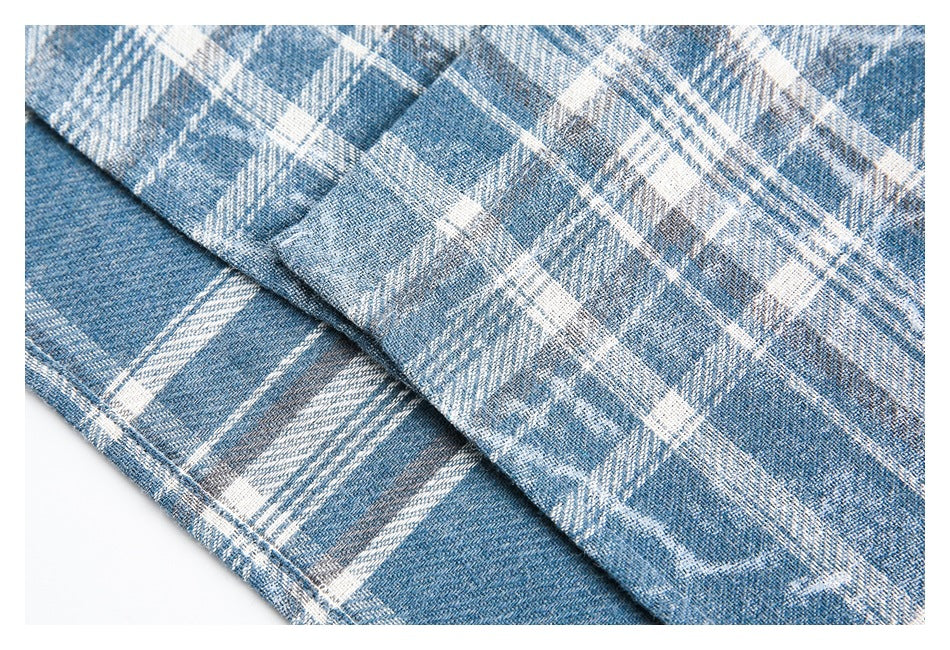 Close-up of blue and white plaid fabric folded to show its textured weave.