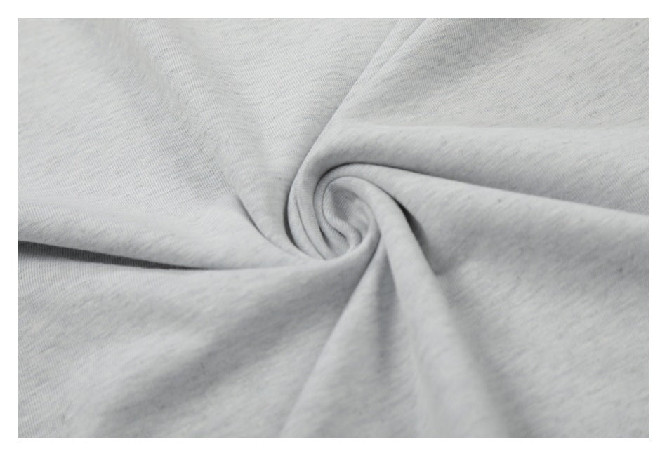 Close-up of light gray knit fabric gathered into a spiral, showing its fine heathered texture.