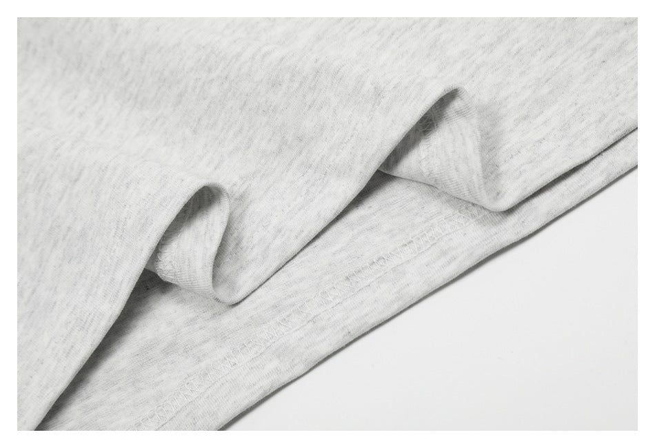Close-up of light gray heathered fabric and stitched hem.