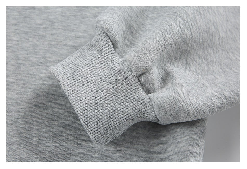 Close-up of a ribbed cuff on the sleeve of a heather gray sweatshirt.