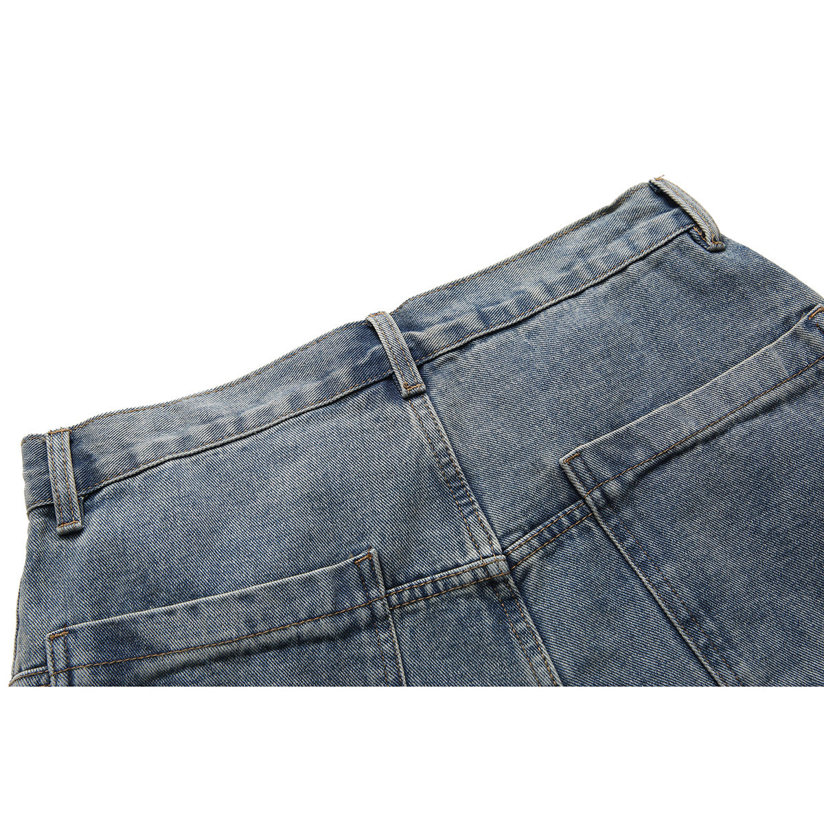 Close-up of the back waistband and pockets of light-wash blue jeans.