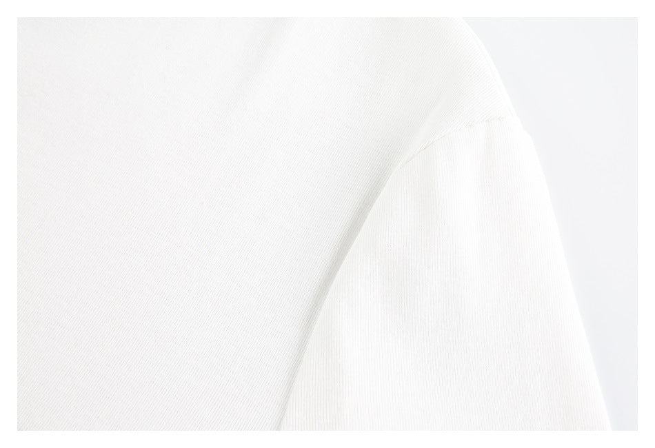 Close-up of the white T-shirt’s shoulder and sleeve seam.